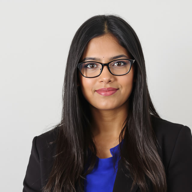Photo for the teacher: a woman with long dark hair and glasses in a black blazer